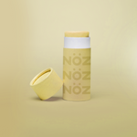 Load image into Gallery viewer, Yellow Nöz Sunscreen bottle is standing, the cap is off and it is placed near the bottle.
